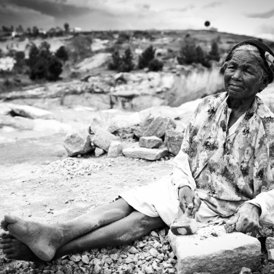 J’ai rencontré cette dame. Assise sur le tas de pierre qui lui restait à casser en miettes, sont dos était courbé, sont marteau aussi. Quand elle relevait la tête vers Arthur, c’était alors une grande dame, fière et belle par son âge.Je m’approchais pour toucher ses mains, je touchais celles d’une statue de 76 ans.1989. Le Père Pedro créer Akamasoa, un village dans la périphérie d’Antananarive qui se veut être la possibilité d’une réinsertion économique et social pour les personnes les plus pauvres de la Grande île.Aujourd’hui, le village abrite aux alentours de vingt-milles personnes, travaillant toutes de leur mains dans un cadre sociale réfléchis et visionnaire. Si les conditions de travail restent souvent précaires, le village d’Akamasoa est une référence nationale en matière de développement.